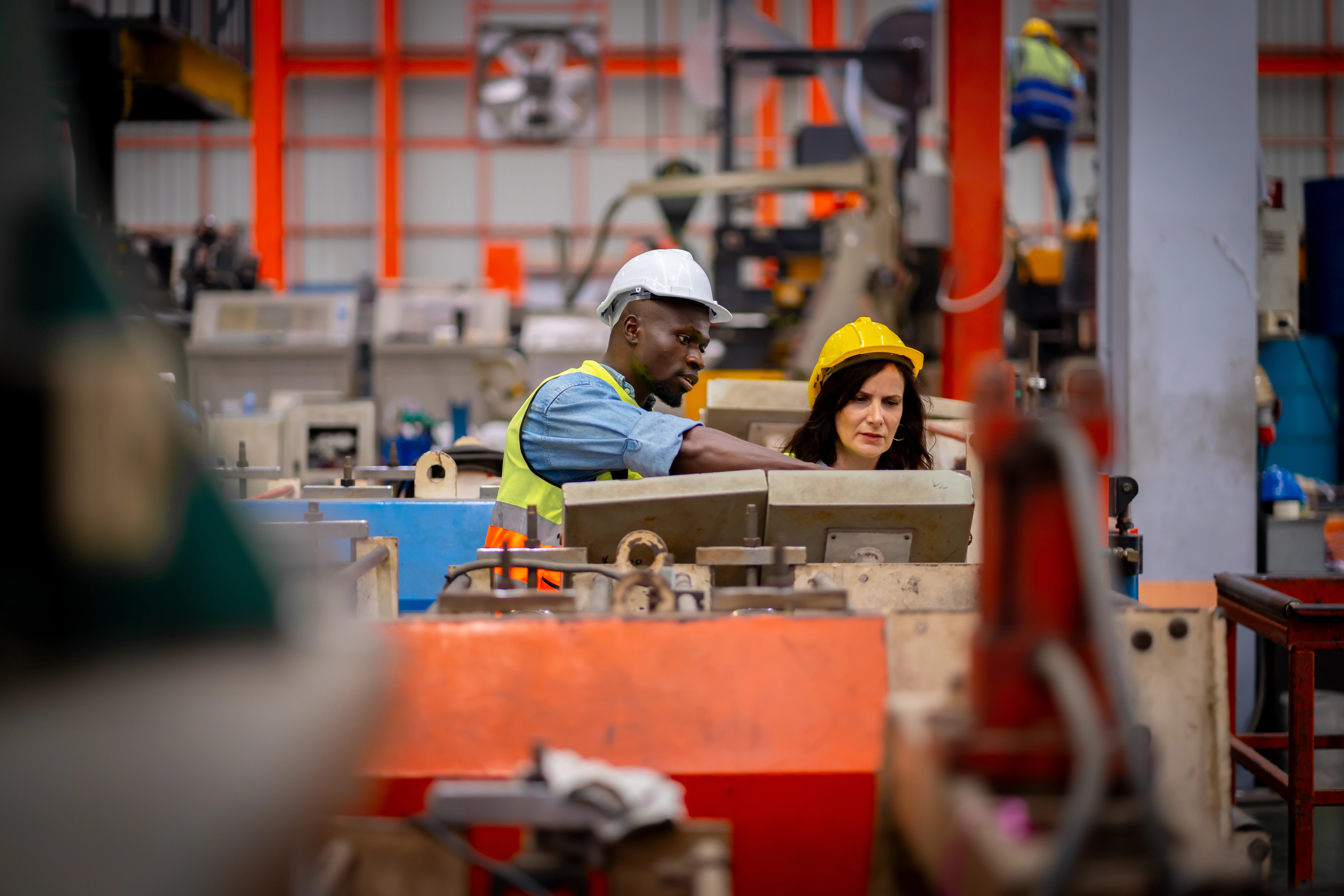 Equipe industrial utilizando máquinas e sistemas no chão de fábrica, representando as tendências da manufatura ligadas à automação, digitalização e eficiência operacional.