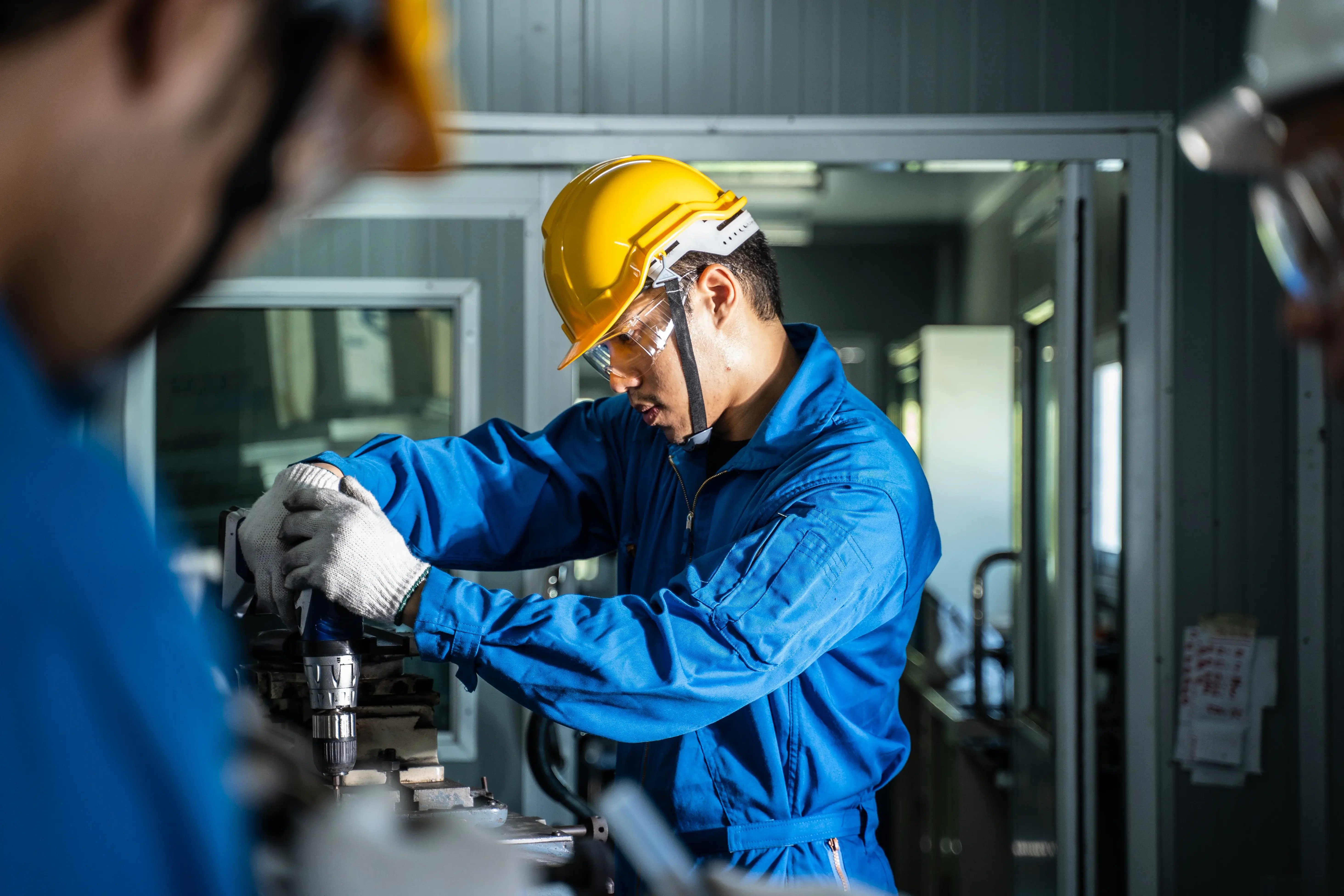 Técnico de manutenção industrial operando máquina em ambiente fabril, representando a análise de disponibilidade total e disponibilidade por falhas dos equipamentos.
