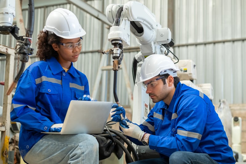 Profissional usando notebook com elementos visuais de proteção de dados e rede segura, representando cibersegurança industrial aplicada a sistemas CMMS e manutenção digital