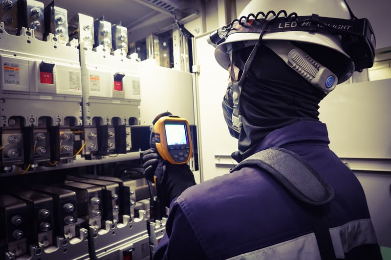 Técnico realizando termografia industrial em painel elétrico com câmera infravermelha para identificar pontos de aquecimento e falhas ocultas nos equipamentos.