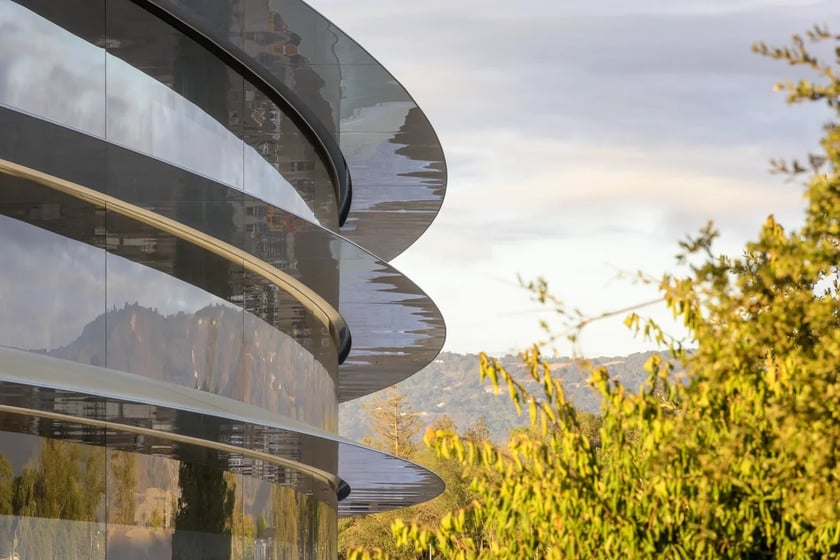 Janelas e curvas do Apple Park ao lado de árvores