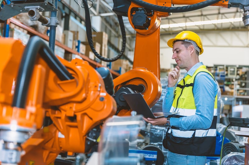Engenheiro inspeciona máquinas durante a gestão de ordens de serviço industriais.