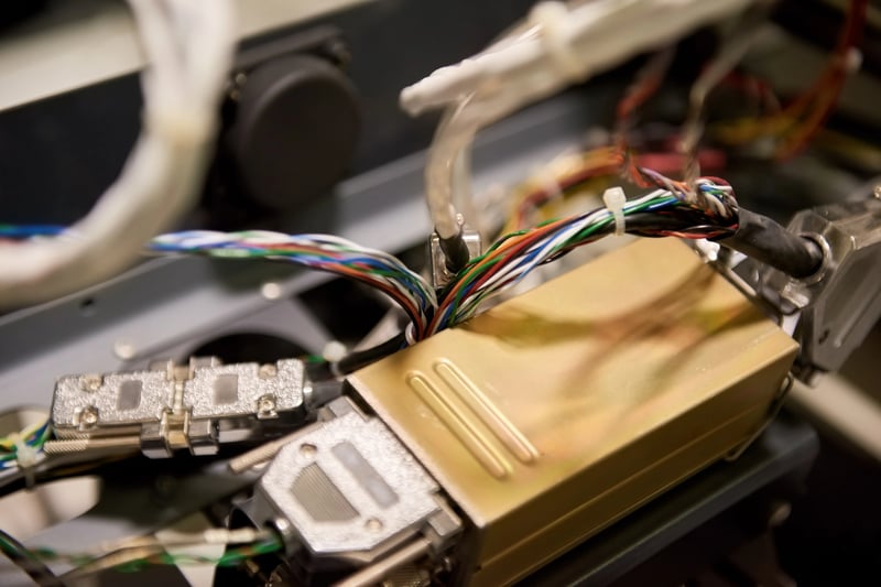 Cabos e componentes industriais conectados a sensores IoT e monitorados por um sistema CMMS.