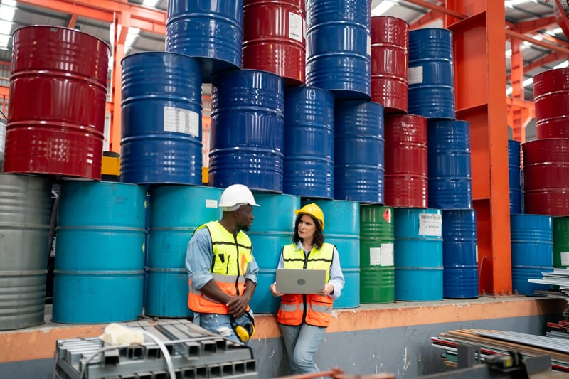 Diferença entre falha e defeito na manutenção em operação industrial com equipe técnica analisando ativos e tambores no estoque