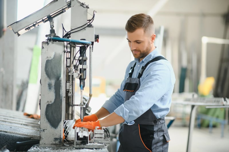 Operador trabalhando em máquina industrial seguindo Boas Práticas de Fabricação e segurança operacional