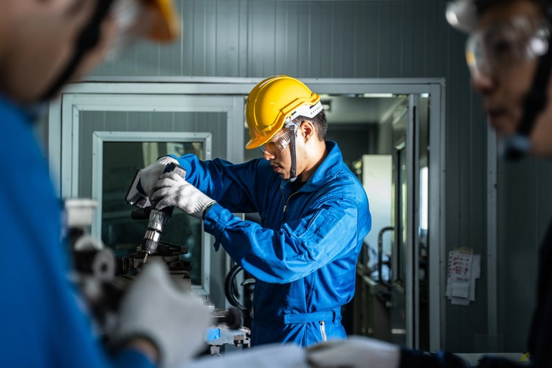 Profissional executando manutenção preventiva em máquina industrial com ferramentas elétricas