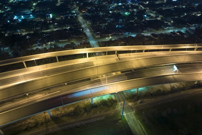 Viaduto urbano iluminado à noite representando riscos estruturais e a necessidade de prevenção contra queda de viaduto.