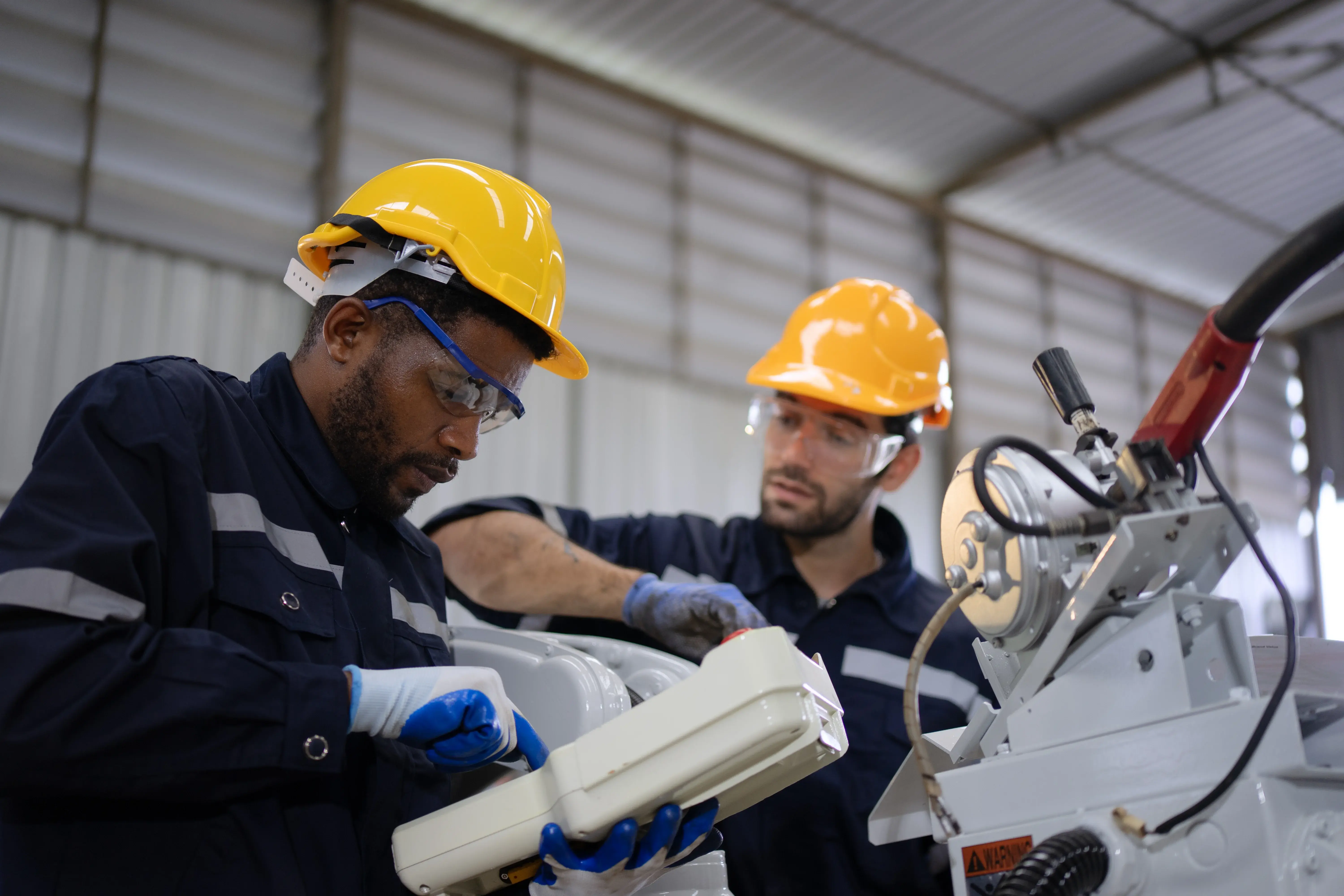 Técnicos de manutenção industrial executando reparo em equipamento, analisando ordem de serviço para reduzir o tempo de ciclo da manutenção