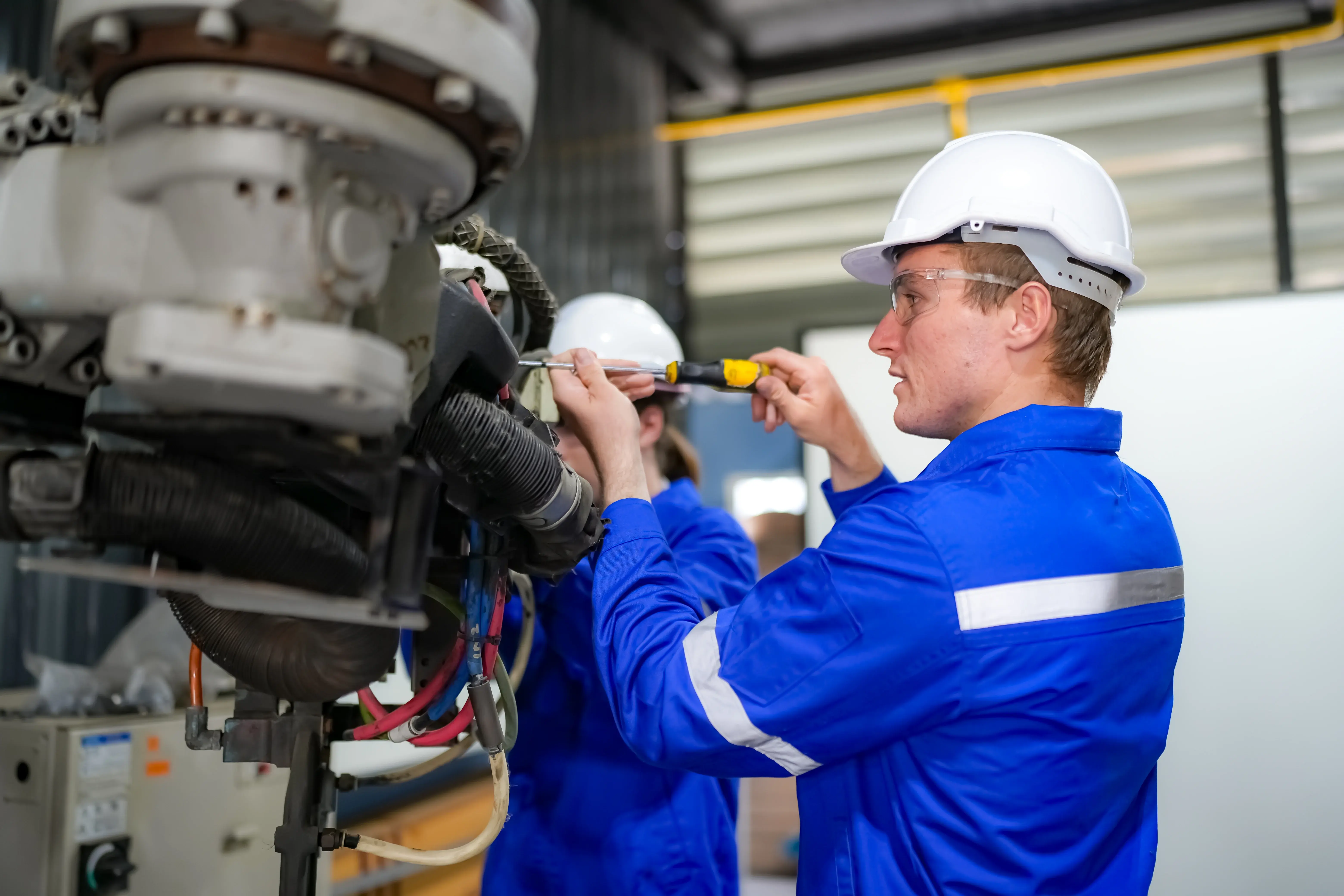 Técnico de manutenção industrial realiza ajuste em equipamento seguindo procedimentos padronizados para aumentar a confiabilidade humana na manutenção e reduzir falhas operacionais.