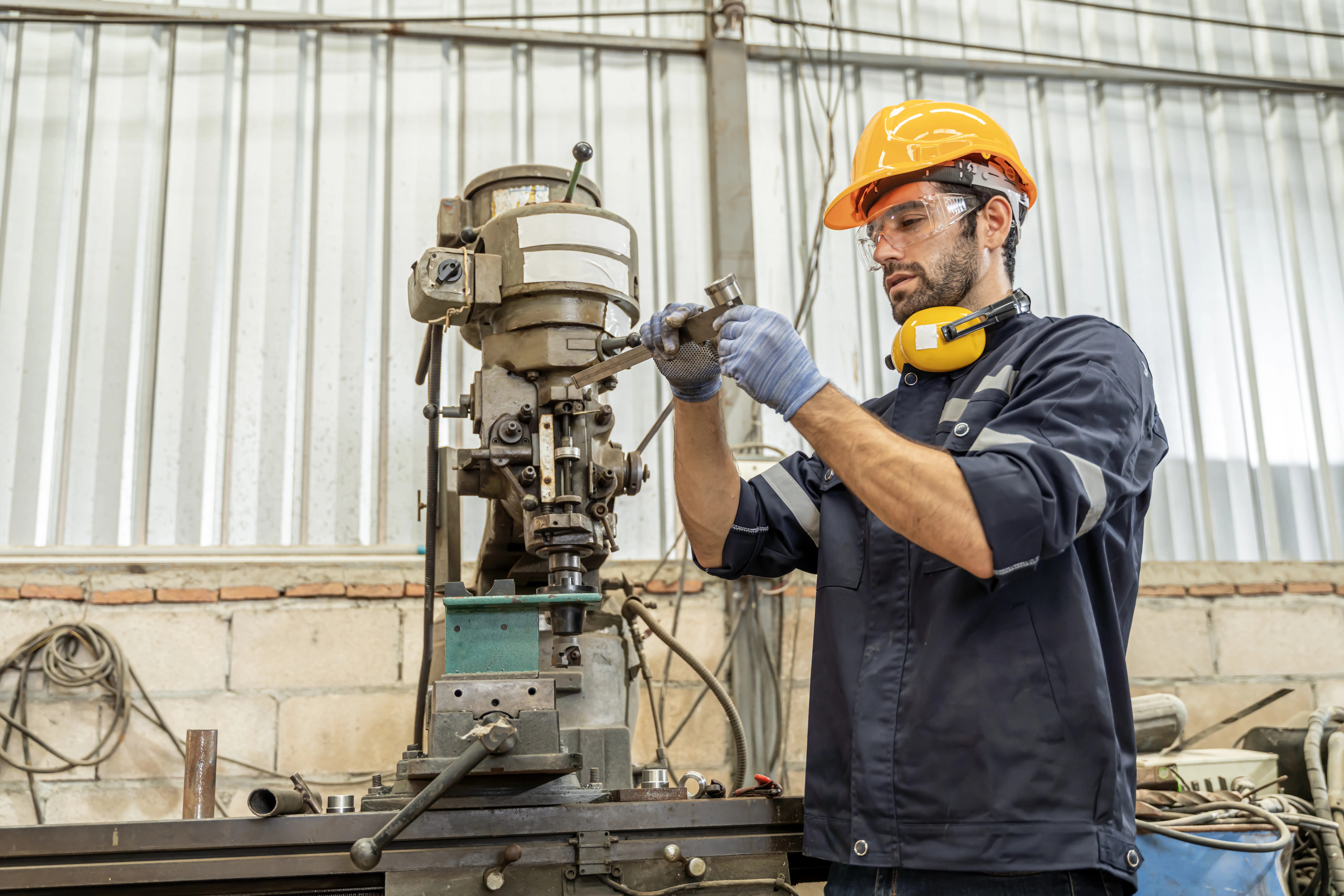 Técnico realizando manutenção e ajuste de equipamento industrial conforme as Boas Práticas de Fabricação