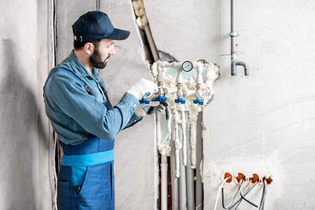 Técnico de mantenimiento comprobando el funcionamiento del sistema de calentamiento de agua.